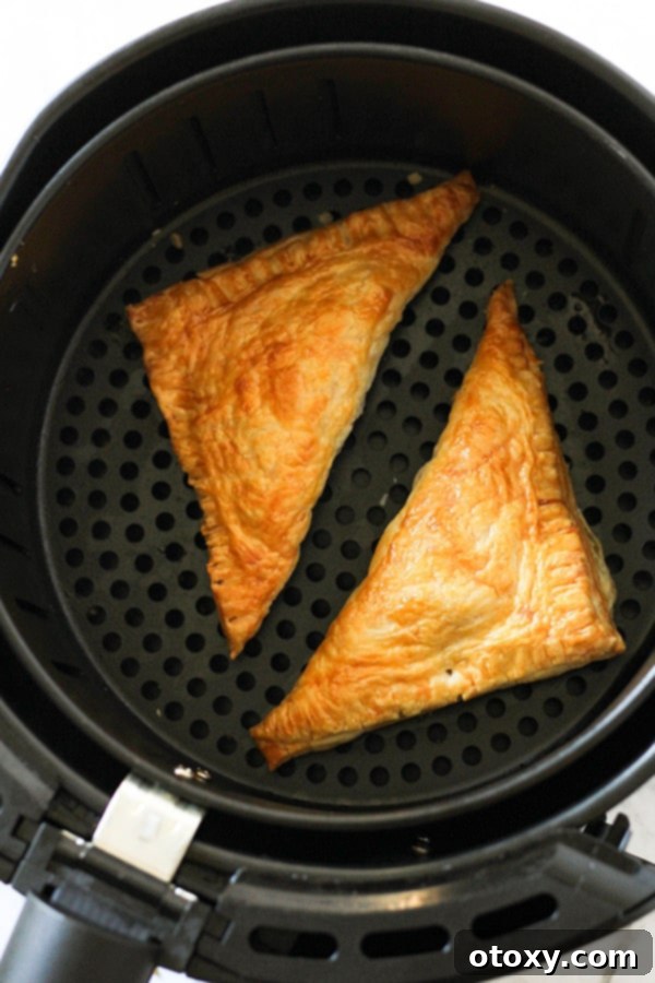 A closer view of a freshly baked air fryer apple turnover, showing its flaky crust and golden color.