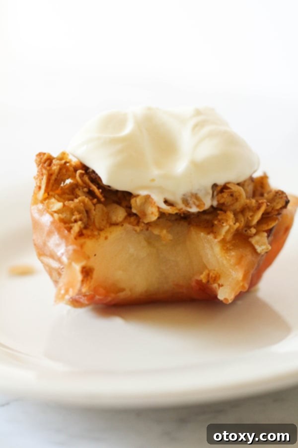 Baked apple topped with ice cream on a white plate, ready to be enjoyed as a delightful dessert.