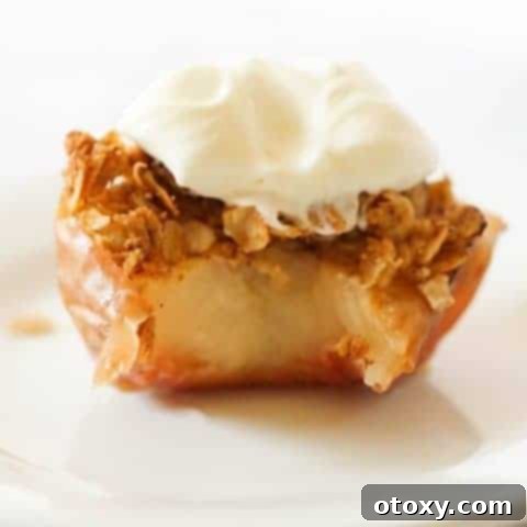 baked apple topped with ice cream on a white plate.