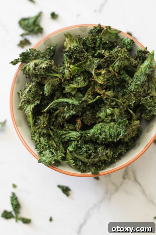 Sweet and Salty Air Fryer Kale Crisps 2 Sweet and salty kale chips served in an elegant white bowl, garnished with a sprinkle of sea salt and a drizzle of maple syrup.