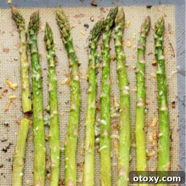 Roasted asparagus spears with lemon slices and grated Parmesan cheese.