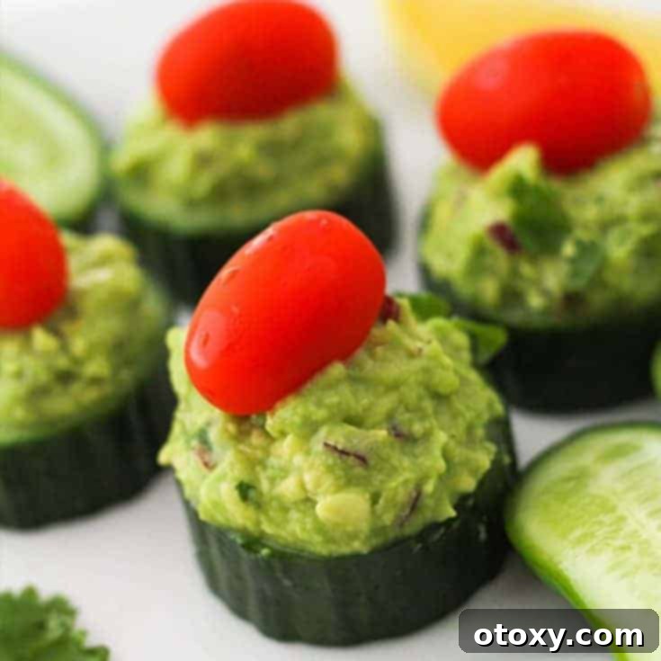 Fresh cucumber bites topped with creamy guacamole, presented as a light and healthy appetizer.