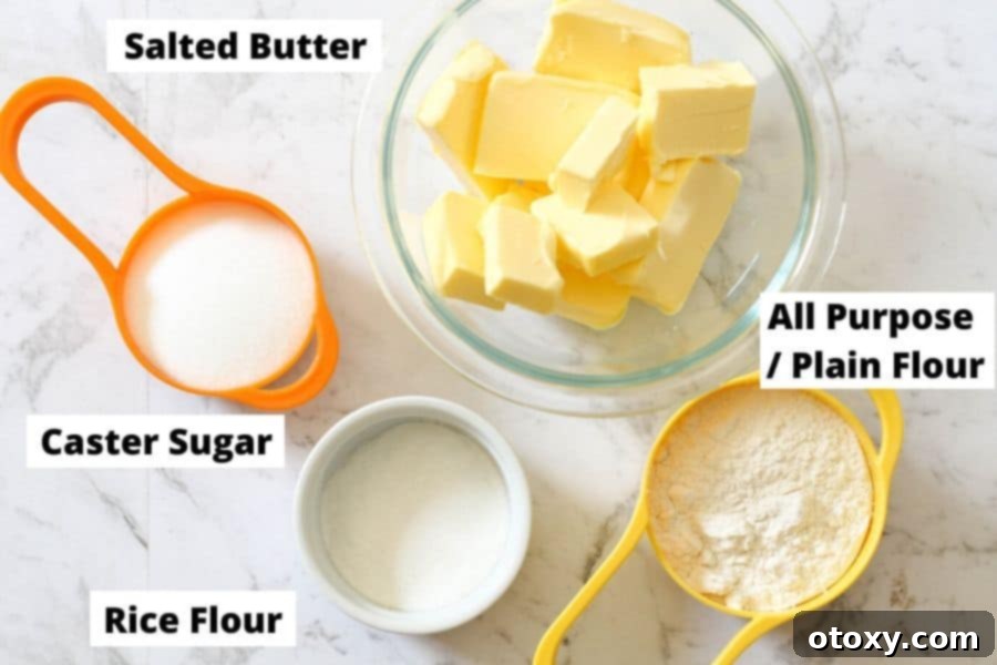 Shortbread ingredients, including butter, sugar, and flour, neatly laid out on a white marble background.