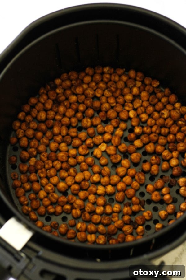 Golden-brown, crispy air-fried chickpeas now fully cooked and still in the air fryer basket.