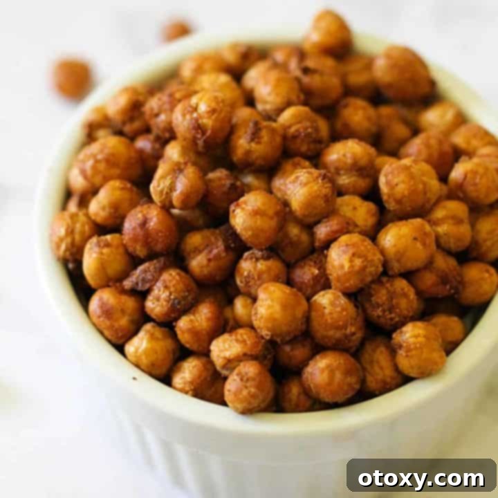 A white bowl filled with perfectly crispy, seasoned air-fried chickpeas, ready for snacking or topping meals.