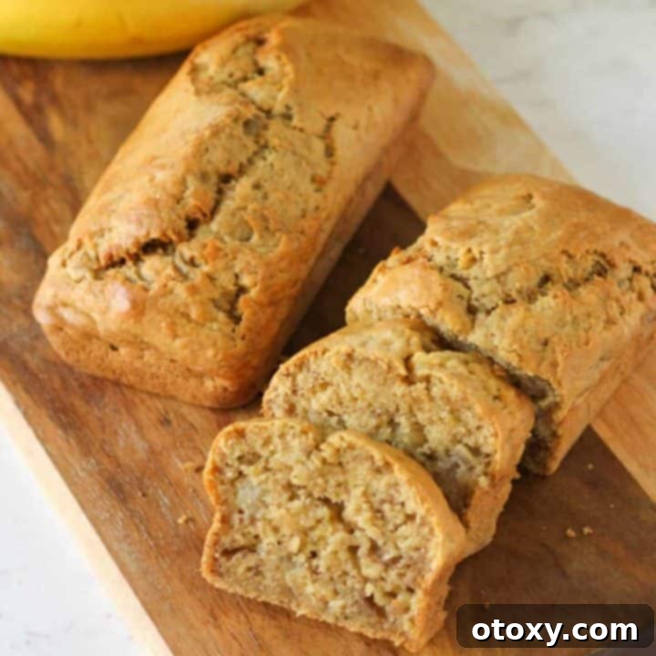 Golden brown Air Fryer Mini Banana Loaves cooling on a wooden board.