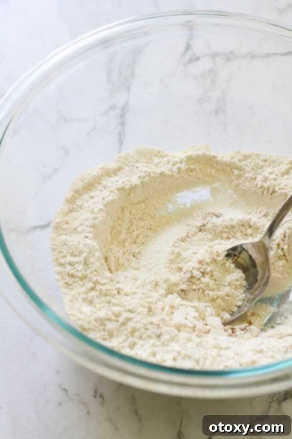 A bowl of white flour mixed with dry baking ingredients, ready to be combined with the wet ingredients for banana bread.