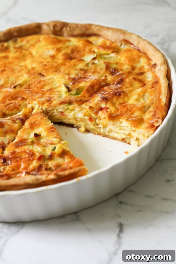 Fresh Garden Quiche 2 A beautifully baked vegetarian quiche in a white quiche dish, ready to be served.