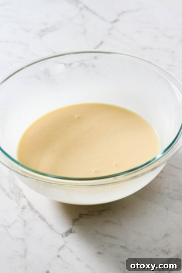Fresh Garden Quiche 9 Beaten eggs, milk, and cream in a clear glass bowl, ready for the quiche filling.