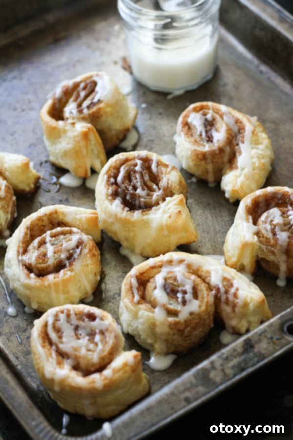 cinnamon rolls in a baking tray covered in glaze.