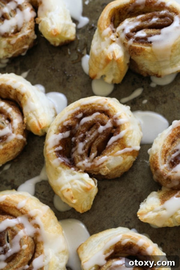 cinnamon rolls on a baking tray covered in glaze.