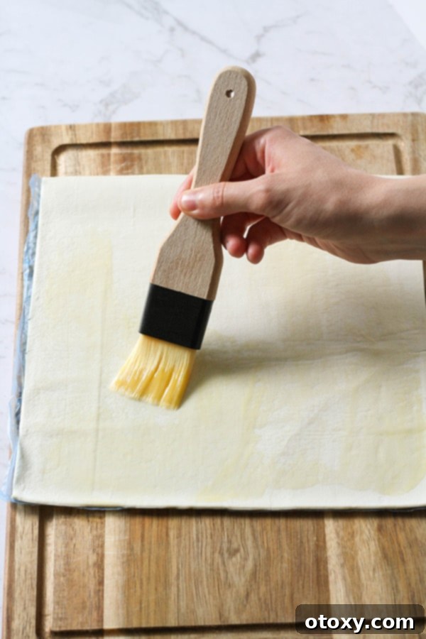 pastry sheet being brushed with butter.