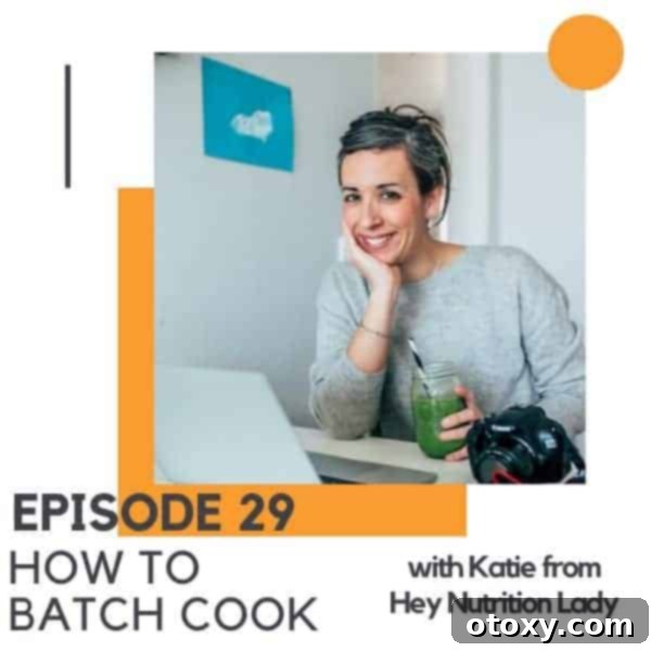 A smiling brunette woman sits comfortably by a laptop, engaging with her work in a bright, inviting space, symbolizing modern productivity and healthy living through efficient meal prep.