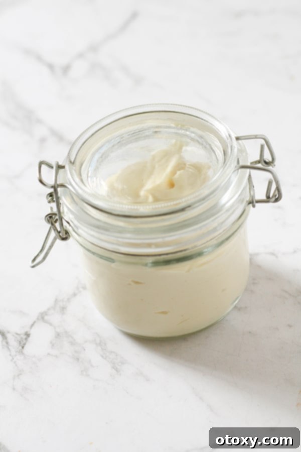 A jar of freshly made Whole30 Mayonnaise, highlighting its smooth and creamy texture.
