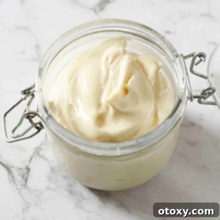Homemade Whole30 Mayonnaise in a glass jar, perfectly emulsified.