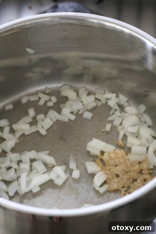 Triple Bean Vegetarian Chili 6 diced onion and garlic being sautéd in a pot.