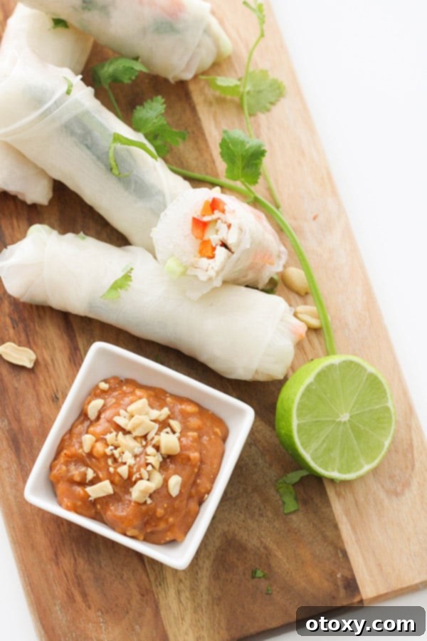 Beautifully arranged chicken rice paper rolls on a rustic wooden serving board, showcasing their vibrant fillings.