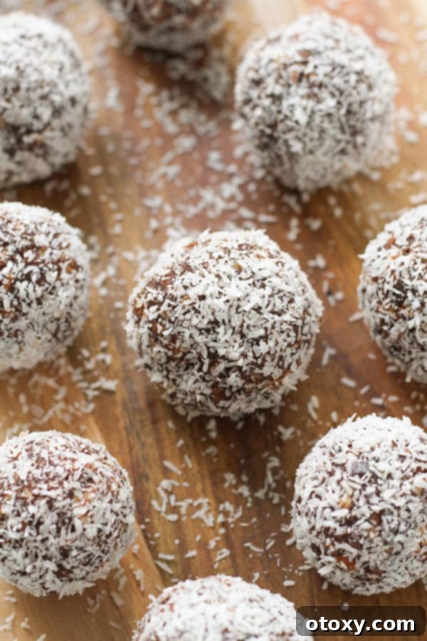 finished chocolate coconut energy balls arranged artfully on a wooden serving board.