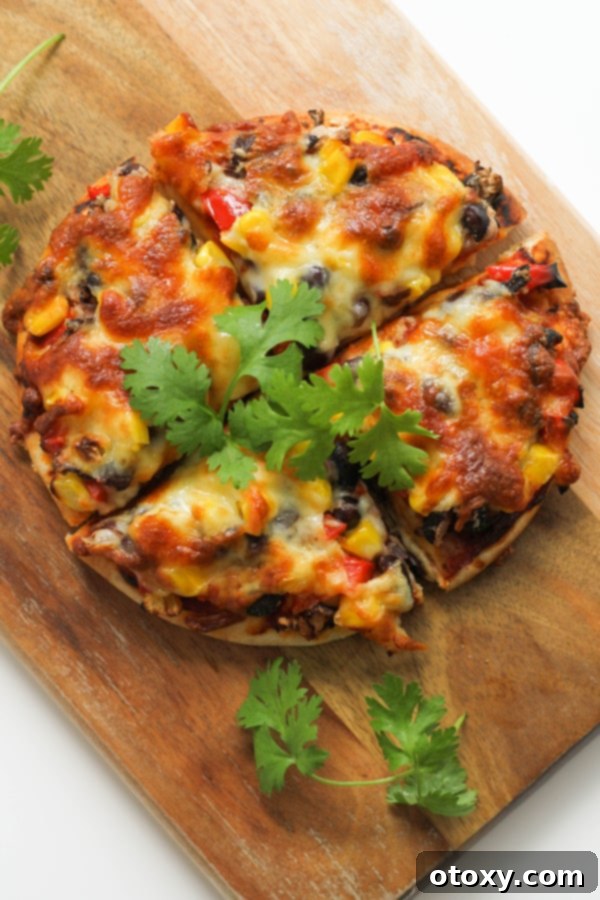 pizza cut into quarters on a wooden board.
