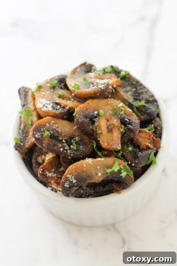 Crispy Air Fried Mushrooms 3 Air fryer mushrooms in a white serving bowl, garnished with fresh herbs.