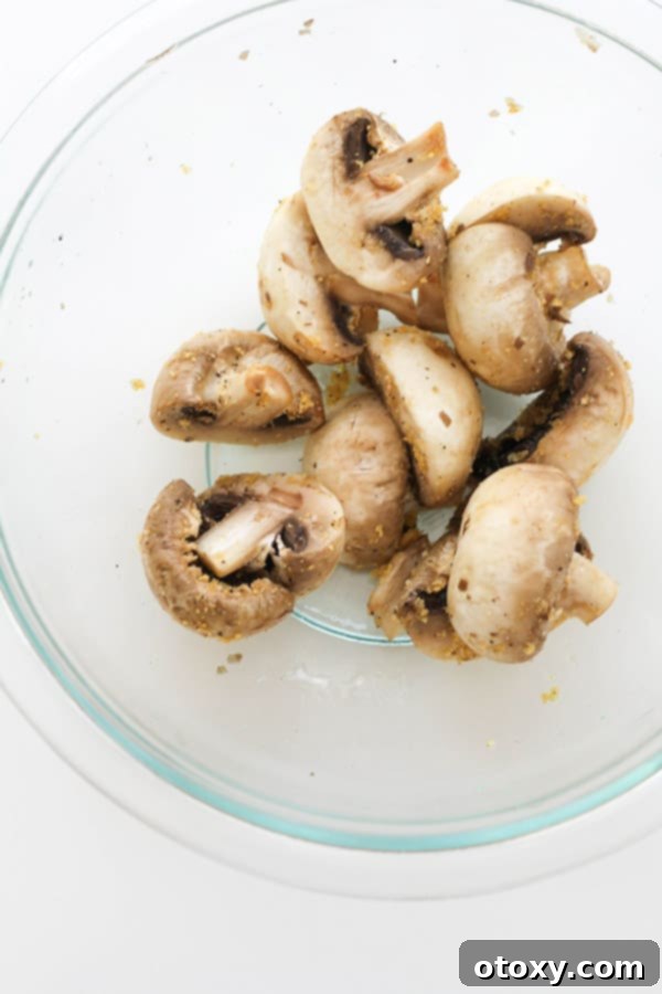Crispy Air Fried Mushrooms 5 Mushrooms tossed with olive oil and seasonings in a glass bowl.