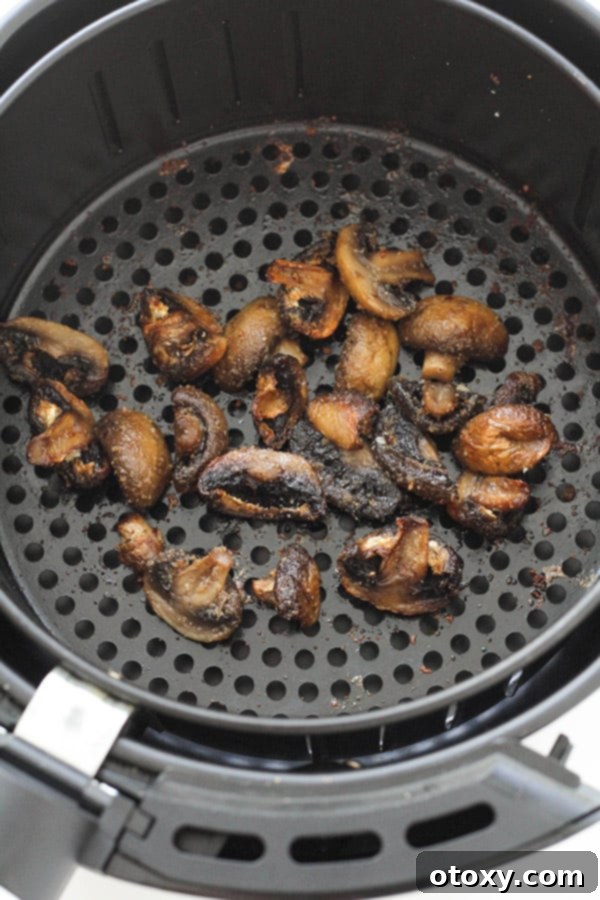 Crispy Air Fried Mushrooms 7 Cooked, golden-brown mushrooms in an air fryer basket.